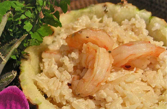 Foto do arroz com camarão e abacaxi dentro de uma metade de abaxi